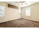 Bright bedroom with plush carpet, ceiling fan, and multiple windows for natural light at 5380 Flowing Spring St, Las Vegas, NV 89122