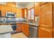 Well-equipped kitchen with granite countertops, stainless steel appliances, and light wood cabinets at 5380 Flowing Spring St, Las Vegas, NV 89122