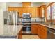Modern kitchen featuring stainless steel appliances, granite countertops, and light wood cabinetry at 5380 Flowing Spring St, Las Vegas, NV 89122