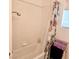 Bathtub with tiled walls and shower head, and a floral curtain at 5415 W Harmon Ave # 2094, Las Vegas, NV 89103