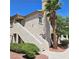 Exterior view of a condo featuring staircase, trimmed hedges, and a stately palm tree on a clear day at 5415 W Harmon Ave # 2094, Las Vegas, NV 89103