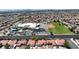 Wide aerial shot captures a neighborhood, a school, and the cityscape beyond, showcasing community amenities at 608 Blooming View Ave, North Las Vegas, NV 89032