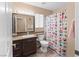Bathroom featuring a decorative shower curtain, granite countertop, and well-lit mirror at 608 Blooming View Ave, North Las Vegas, NV 89032