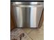 Stainless steel dishwasher in kitchen with tile flooring and wooden cabinets at 608 Blooming View Ave, North Las Vegas, NV 89032