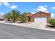 Single-story home featuring a terracotta roof, palm trees, an attached two-car garage, and well-maintained landscaping at 608 Blooming View Ave, North Las Vegas, NV 89032