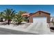 Inviting single story home featuring desert landscaping, tile roof, two-car garage, and solar panels at 608 Blooming View Ave, North Las Vegas, NV 89032