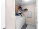 Functional laundry room equipped with washer, dryer, and storage shelves at 608 Blooming View Ave, North Las Vegas, NV 89032