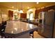 Gourmet kitchen with stainless steel fridge, granite island, and dark cabinets at 6339 Sharp Rock Ct, Las Vegas, NV 89139