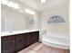 Bright bathroom with double sinks, soaking tub, and dark wood cabinetry at 6465 Grande River Ct, Las Vegas, NV 89139