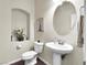Charming powder room with pedestal sink, decorative mirror, and floral accents at 6465 Grande River Ct, Las Vegas, NV 89139
