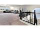 Spacious carpeted loft area with windows, and black metal railing, offering plenty of room for activities at 6465 Grande River Ct, Las Vegas, NV 89139