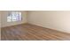 A serene bedroom with light wood flooring, a window, and neutral walls at 6842 Greengrove Dr, Las Vegas, NV 89103
