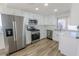 Bright kitchen featuring stainless steel appliances, white cabinets, and light wood flooring at 6842 Greengrove Dr, Las Vegas, NV 89103