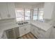 A kitchen area with white cabinets, stainless appliances, quartz countertops, and view of the pool at 6842 Greengrove Dr, Las Vegas, NV 89103