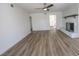 Spacious living room with light wood flooring, white walls, ceiling fan, and fireplace at 6842 Greengrove Dr, Las Vegas, NV 89103