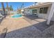 Backyard oasis featuring a pristine pool, covered patio, and beautiful desert landscaping at 6842 Greengrove Dr, Las Vegas, NV 89103