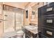 The bathroom features a shower, a toilet, and a sink with black marble countertops and wooden furnishings at 7296 Mission Hills Dr, Las Vegas, NV 89113