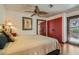 Cozy bedroom featuring a ceiling fan, closet with red doors, and a door to the outdoor living area at 7296 Mission Hills Dr, Las Vegas, NV 89113