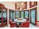 Bright dining area with large windows, red upholstered chairs, and a unique circular table at 7296 Mission Hills Dr, Las Vegas, NV 89113