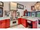 Bright kitchen featuring a Wolf range, stainless steel hood, red cabinetry, and marble countertops at 7296 Mission Hills Dr, Las Vegas, NV 89113