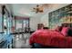 Bedroom with red bedding, dark hardwood floors, and unique artwork on the walls at 7296 Mission Hills Dr, Las Vegas, NV 89113