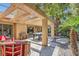 An outdoor patio area with seating, a pergola, and lush landscaping at 7296 Mission Hills Dr, Las Vegas, NV 89113