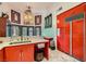 Butler's Pantry featuring red cabinets, a white marble countertop, and a stainless steel sink at 7296 Mission Hills Dr, Las Vegas, NV 89113