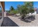 View of a zero-scaped backyard with trees and a stone ground cover on a sunny day at 7448 Lintwhite St, North Las Vegas, NV 89084