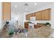 Open-concept kitchen with granite countertops, wood cabinetry, a stainless steel sink and white appliances at 7448 Lintwhite St, North Las Vegas, NV 89084