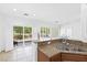 Bright kitchen with granite countertops, wood cabinets, and a view of the backyard through shuttered glass doors at 7448 Lintwhite St, North Las Vegas, NV 89084