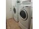 Bright laundry room with tile flooring, side-by-side washer and dryer, and overhead shelving at 7448 Lintwhite St, North Las Vegas, NV 89084