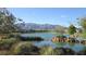 Picturesque pond view with rock features and mountain backdrop in this serene community at 7448 Lintwhite St, North Las Vegas, NV 89084