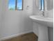 Powder room featuring a pedestal sink, modern faucet, and a framed window providing natural light at 7791 Misty Oaks Ave, Las Vegas, NV 89113
