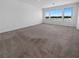 Spacious bedroom with neutral carpet and three windows offering neighborhood views at 7791 Misty Oaks Ave, Las Vegas, NV 89113