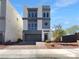 Beautiful, modern three-story home featuring a well-manicured front yard and gray color scheme at 7791 Misty Oaks Ave, Las Vegas, NV 89113
