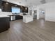 Modern kitchen with dark cabinetry, an island, stainless steel appliances, and wood-look tile flooring at 7791 Misty Oaks Ave, Las Vegas, NV 89113