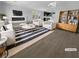 Bright living room with white sofas, two armchairs, fireplace, and wood-look flooring at 7791 Misty Oaks Ave, Las Vegas, NV 89113