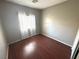 Cozy bedroom with hardwood floors, a window with blinds, and neutral paint at 971 Whispering Grove Ave, Las Vegas, NV 89123