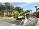 Community entrance featuring lush landscaping and mature trees, creating a welcoming first impression at 971 Whispering Grove Ave, Las Vegas, NV 89123