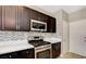 Close up of the updated kitchen area with stainless steel appliances, countertops, and dark wood cabinets at 971 Whispering Grove Ave, Las Vegas, NV 89123