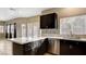 Open kitchen layout with dark cabinets, a center island, stainless steel appliances, and modern fixtures at 971 Whispering Grove Ave, Las Vegas, NV 89123