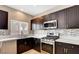 Well-equipped kitchen with updated stainless steel appliances, granite countertops, and stylish tile backsplash at 971 Whispering Grove Ave, Las Vegas, NV 89123