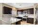Modern kitchen with dark wood cabinetry, quartz countertops, and stainless steel appliances at 971 Whispering Grove Ave, Las Vegas, NV 89123