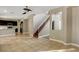 Open concept living room with tile flooring, view of the kitchen, and staircase at 971 Whispering Grove Ave, Las Vegas, NV 89123