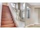 Beautiful staircase with wood steps, white railing, and abundant natural light from the large windows at 971 Whispering Grove Ave, Las Vegas, NV 89123