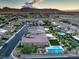 Neighborhood shot of a well-maintained community, showing pools, yards, and homes with mountain views at 9760 Arch Canyon Ct, Las Vegas, NV 89149
