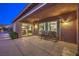 The covered back patio features dark wood outdoor furniture and sliding glass doors that look into the home at 9760 Arch Canyon Ct, Las Vegas, NV 89149