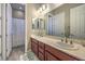 This dual vanity bathroom features framed mirrors, recessed lighting, and a shower-tub combo at 9760 Arch Canyon Ct, Las Vegas, NV 89149