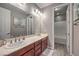 This bathroom is designed with dual sinks, wood-style floors, and features a bath and shower at 9760 Arch Canyon Ct, Las Vegas, NV 89149