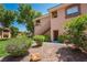 Condo exterior featuring manicured landscaping, mature trees, and private entrances at 1050 E Cactus Ave # 1128, Las Vegas, NV 89183